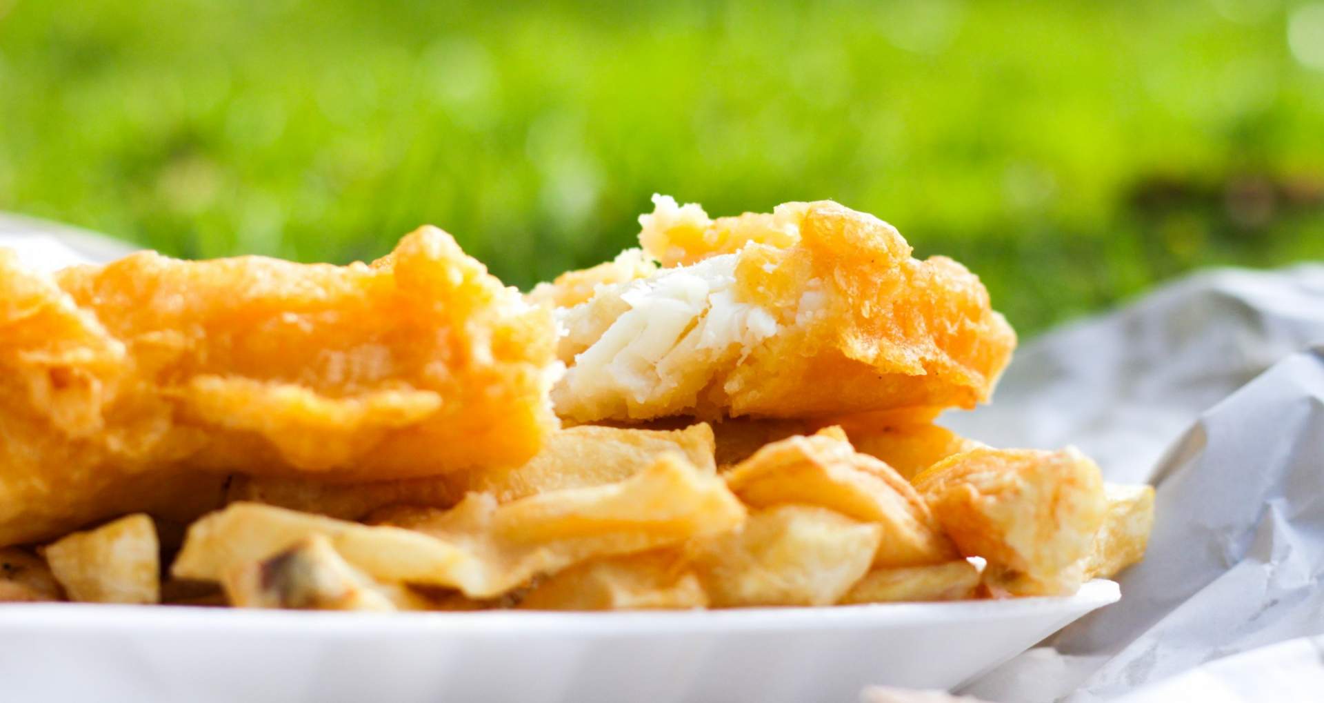 Battered white fish with chips wrapped in paper